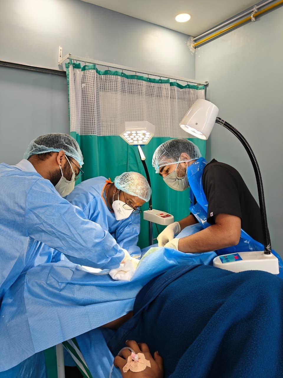 Three surgeons performing a procedure in the minor theatre