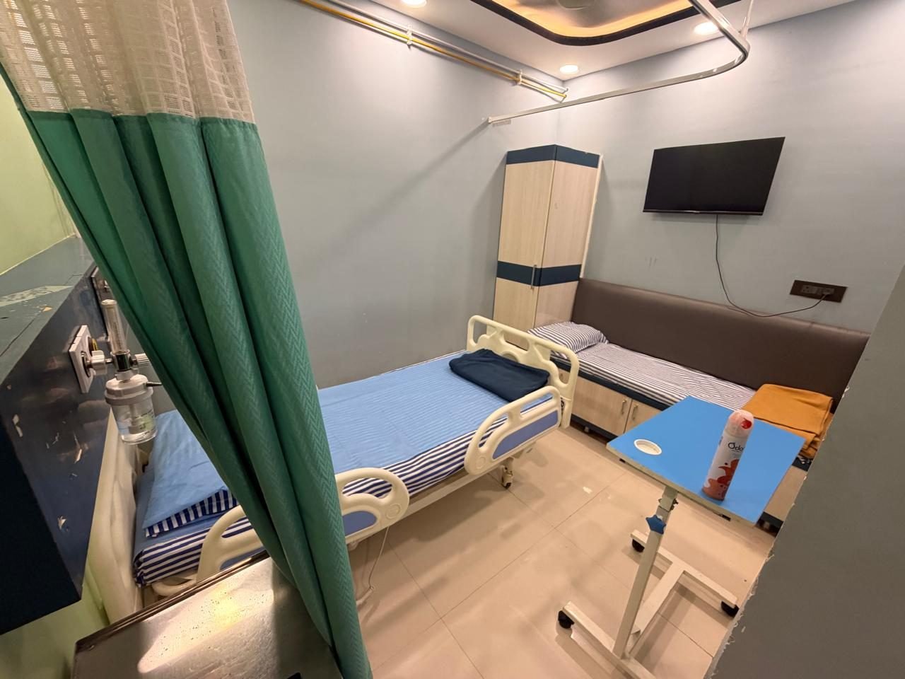 Private patient room with an adjustable bed, oxygen point, attendant sofa and TV